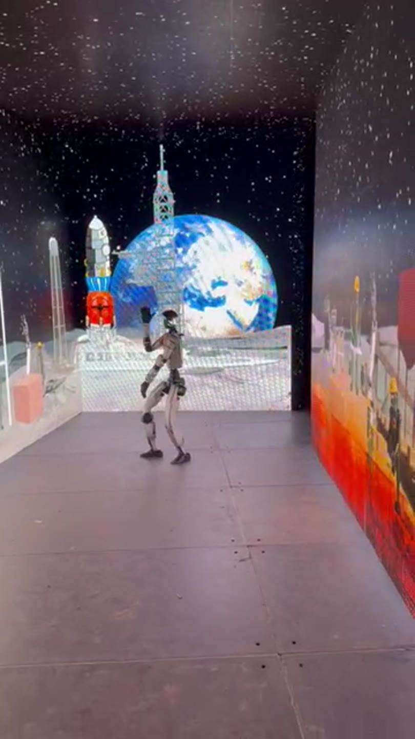 Robot na pódiu s projekcí planety Země